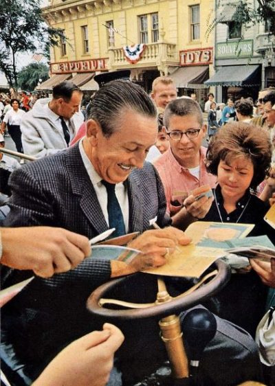Walt Disney signing autographs at Disneyland, 1963